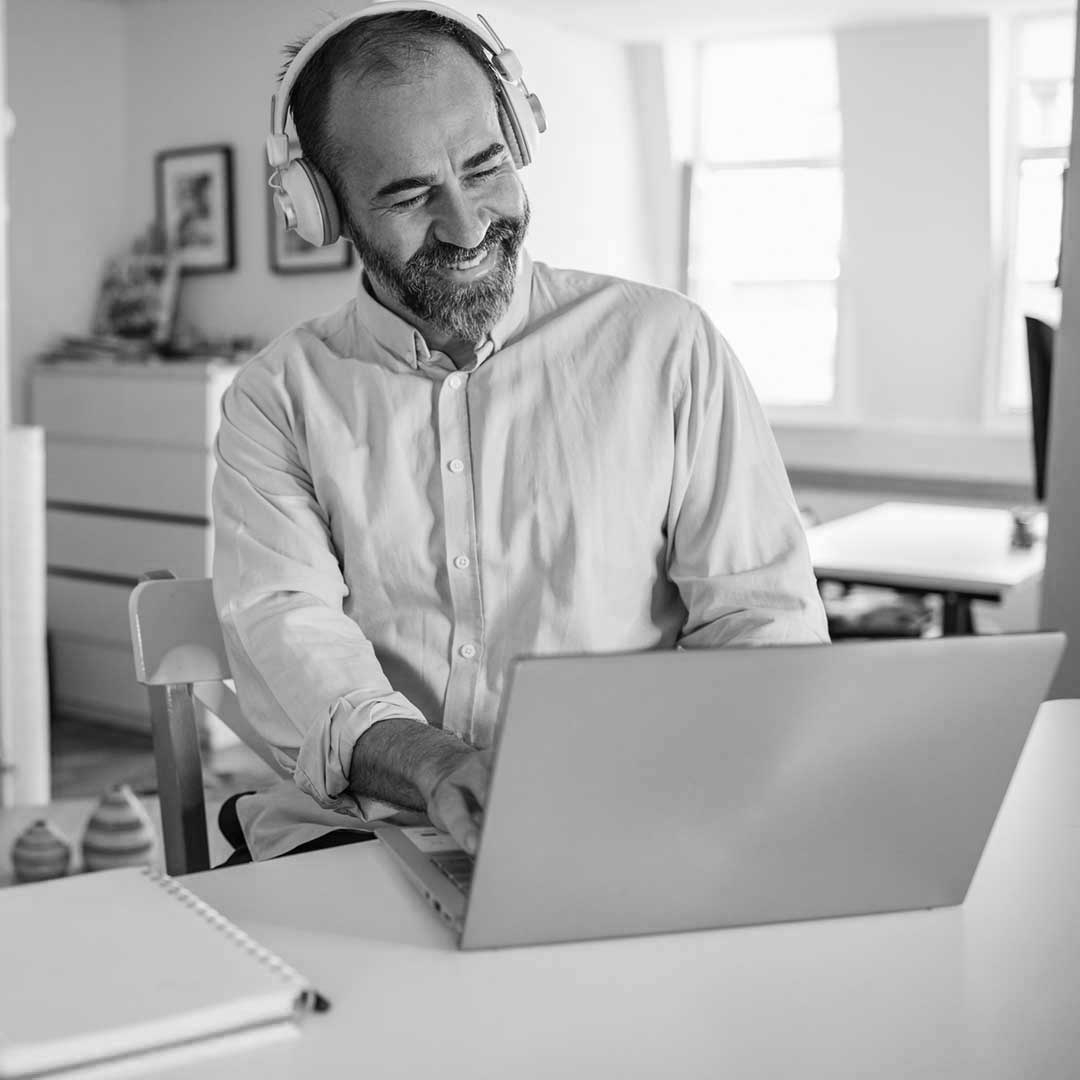 Homme qui regarde en souriant son ordinateur